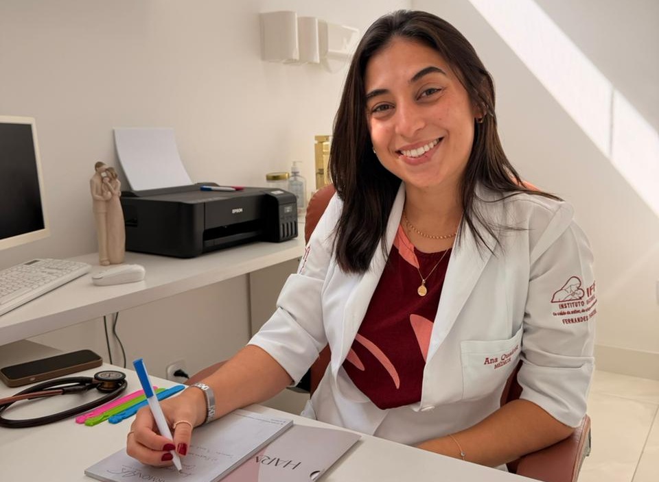 Dra. Ana Carolina Queiroz sorrindo em seu consultório